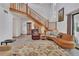 Bright and airy living room showcasing a staircase, wood-look floors, and ample natural light at 749 E Wisconsin Ave, Orange City, FL 32763