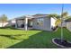 Picture of the backyard, showing the covered patio, lush grass, and new landscaping at 875 Honey Petal Ln, Deland, FL 32720