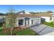 Attractive single-story home featuring a stone facade, gray exterior, paver driveway, and well-manicured lawn at 875 Honey Petal Ln, Deland, FL 32720