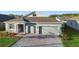 Beautiful single-story home with a gray exterior, brick driveway, well-maintained lawn, and inviting curb appeal at 875 Honey Petal Ln, Deland, FL 32720