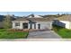 Beautiful single-story home featuring a grey exterior, stone accents, and brick paved driveway at 875 Honey Petal Ln, Deland, FL 32720