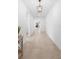 Inviting hallway with neutral tile flooring, pristine white walls, and a stylish pendant light fixture at 875 Honey Petal Ln, Deland, FL 32720