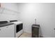 Well lit laundry room includes a washer, dryer, storage rack, and wine cooler at 875 Honey Petal Ln, Deland, FL 32720