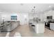 Open-concept living room and kitchen with an island, stainless appliances, and a comfortable seating area at 875 Honey Petal Ln, Deland, FL 32720