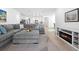 Welcoming living room with a gray sectional, electric fireplace, and access to the outdoor area at 875 Honey Petal Ln, Deland, FL 32720