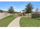 Fenced community playground with various play equipment and bench seating at 875 Honey Petal Ln, Deland, FL 32720