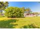 Well-maintained backyard with mature trees, showcasing the home's exterior and the landscaped surroundings at 953 Pineapple Rd, South Daytona, FL 32119