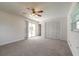 Bright, carpeted bedroom with a ceiling fan, closet, and sliding door to the backyard at 953 Pineapple Rd, South Daytona, FL 32119