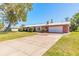 Lovely brick home featuring a long concrete driveway and lush, green lawn at 953 Pineapple Rd, South Daytona, FL 32119