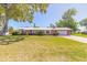Charming brick home featuring a metal roof and a lush green lawn, set beneath a clear blue sky at 953 Pineapple Rd, South Daytona, FL 32119