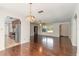 Open living space features hardwood floors, chandelier, and access to kitchen at 953 Pineapple Rd, South Daytona, FL 32119