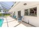 A view of the home's outdoor pool and lanai area with blue patio furniture and white exterior at 953 Pineapple Rd, South Daytona, FL 32119