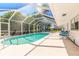Screened-in pool with a covered patio and an outdoor seating area with blue chairs, perfect for relaxation and outdoor entertainment at 953 Pineapple Rd, South Daytona, FL 32119