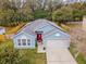 An aerial shot of a blue single-story house, showcasing its gray roof and solar panels at 971 Cascades Park Trl, Deland, FL 32720