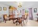 Bright dining room showcasing a classic wooden table, china cabinet, and stylish decor on neutral tile floors at 971 Cascades Park Trl, Deland, FL 32720