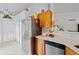 Bright kitchen area with stainless steel refrigerator, wooden cabinets, and white countertops at 971 Cascades Park Trl, Deland, FL 32720