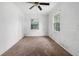 A bedroom with white walls, a ceiling fan, two windows and carpet flooring at 1014 W Euclid Ave, Deland, FL 32720