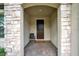 Inviting front porch with stone accents, brick flooring, and a charming seating area at 12058 Ryegrass Trl, Orlando, FL 32824