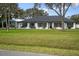 Single-story home with lush lawn and mature tree, complemented by a detached garage at 125 Country Circle W Dr, Port Orange, FL 32128