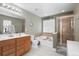 Well-appointed bathroom featuring double sinks, a soaking tub, and a glass-enclosed shower, and natural light at 1318 Pup Fish Ln, Deland, FL 32724