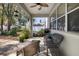 Covered patio area with wicker furniture and views of the surrounding greenery at 1318 Pup Fish Ln, Deland, FL 32724