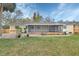 Expansive backyard featuring a screened lanai and a lush green lawn with brick paver patio at 141 N Mcdonald Ave, Deland, FL 32724