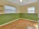 Bedroom featuring hardwood floors, two-tone walls, and two windows for ample lighting at 141 N Mcdonald Ave, Deland, FL 32724