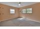 Bedroom with neutral carpet, ceiling fan, and two windows providing natural light at 141 N Mcdonald Ave, Deland, FL 32724