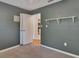 Bedroom with neutral carpet, muted green walls, white trim, and a peek into the kitchen at 141 N Mcdonald Ave, Deland, FL 32724