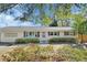 Charming single-story home with blue shutters, flower beds and light-yellow painted exterior at 141 N Mcdonald Ave, Deland, FL 32724