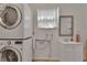 Laundry room features a stacked washer and dryer, sink, and a mirror at 141 N Mcdonald Ave, Deland, FL 32724