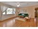 Bright living room features hardwood floors, a ceiling fan, and a large window with sheer curtains at 141 N Mcdonald Ave, Deland, FL 32724