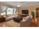 Cozy living room with large windows, neutral furniture, hardwood floors, and a ceiling fan at 141 N Mcdonald Ave, Deland, FL 32724