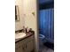 Compact bathroom featuring a sink, vanity, toilet, and tiled shower with a floral shower curtain at 1420 Felton St, Deltona, FL 32725
