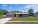 Inviting single-story home with attached garage, manicured lawn, and screened pool in the backyard at 1420 Felton St, Deltona, FL 32725