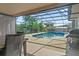 Relaxing screened-in pool area with clear blue water, dining set, and BBQ grill at 1420 Felton St, Deltona, FL 32725
