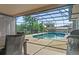 Enclosed backyard pool with patio furniture and grill, perfect for outdoor gatherings at 1420 Felton St, Deltona, FL 32725