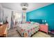 Bright bedroom featuring a comfortable bed with a colorful quilt and a vibrant turquoise accent wall at 1489 Casey Ln, Port Orange, FL 32129
