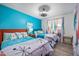 Comfortable bedroom with two beds, bright blue accent wall, and modern light fixture at 1489 Casey Ln, Port Orange, FL 32129