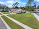 Charming single-story home with a well-maintained lawn, white picket fence, and mature trees at 1489 Casey Ln, Port Orange, FL 32129