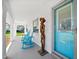 Inviting front porch with rocking chairs, a unique wooden sculpture, and a turquoise front door at 1489 Casey Ln, Port Orange, FL 32129