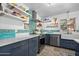 The updated kitchen features stylish blue cabinets, open shelving, and modern stainless-steel appliances at 1489 Casey Ln, Port Orange, FL 32129