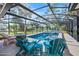 Inviting screened-in pool area features a stone fire pit and comfortable outdoor seating, perfect for relaxing at 1489 Casey Ln, Port Orange, FL 32129