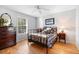 Cozy bedroom features a metal bed frame, wood floors, and an antique dresser at 1552 Covered Bridge Dr, Deland, FL 32724