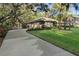 Manicured front yard with a brick home, lush landscaping, and a long driveway at 1552 Covered Bridge Dr, Deland, FL 32724