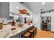 Kitchen featuring long marble countertop, stainless appliances, island seating, and white cabinets at 1552 Covered Bridge Dr, Deland, FL 32724