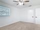 Bedroom features plush carpeting, a window offering natural light, and a door at 1579 Brady Dr, Deltona, FL 32725