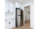 Bright kitchen features white cabinets, stainless steel refrigerator, and modern hardware at 1579 Brady Dr, Deltona, FL 32725