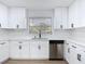 Charming kitchen offers stainless dishwasher and sink, plus white cabinets with black hardware at 1579 Brady Dr, Deltona, FL 32725