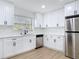 Modern kitchen features white cabinets, stainless appliances, and stylish backsplash at 1579 Brady Dr, Deltona, FL 32725